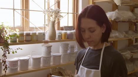 Young-female-potter-working-in-her-studio