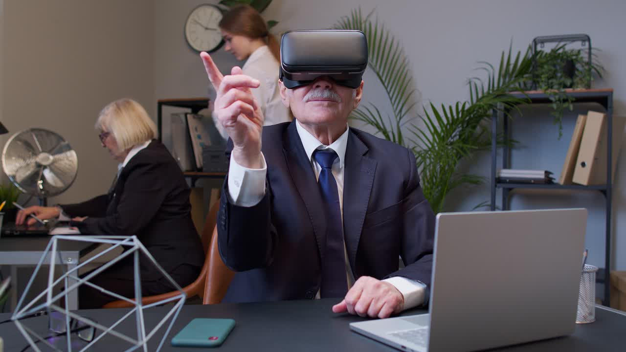 старший бизнесмен в vr-кассете указывает пальцем в офисе.