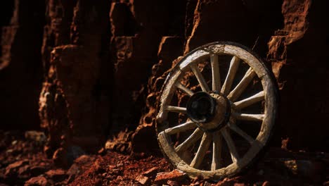 old wooden cart wheel on stone rocks