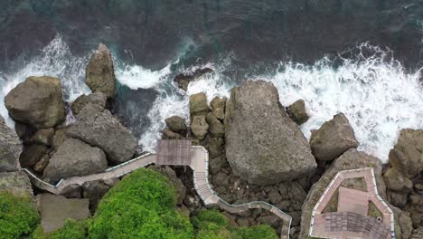 Aerial-pedestal-capturing-the-rocky-walkway-at-Black-Dwarf-Cave-scenic-area,-upward-tilting-reveals-beautiful-seascape-and-endless-horizon-at-Xiaoliuqiu,-Lambai-island,-Pingtung-county,-Taiwan