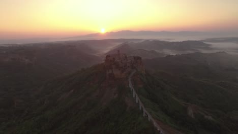 Una-Vista-Aérea-Muestra-La-Carretera-Que-Conduce-A-Civita-Di-Bagnoregio-Italia-Al-Atardecer