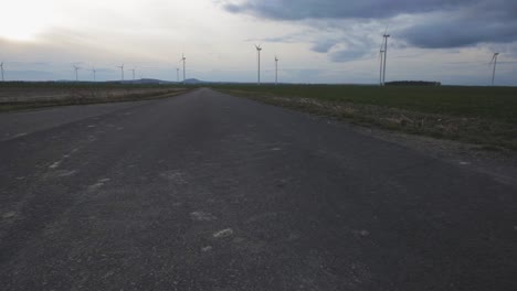 windturbinen, die sich unter dem dunklen bewölkten himmel in zlotoryja, polen drehen - weites schwenken