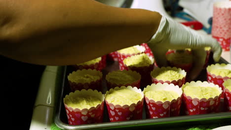 beating cupcakes against baking sheet to get air bubbles out of the batter