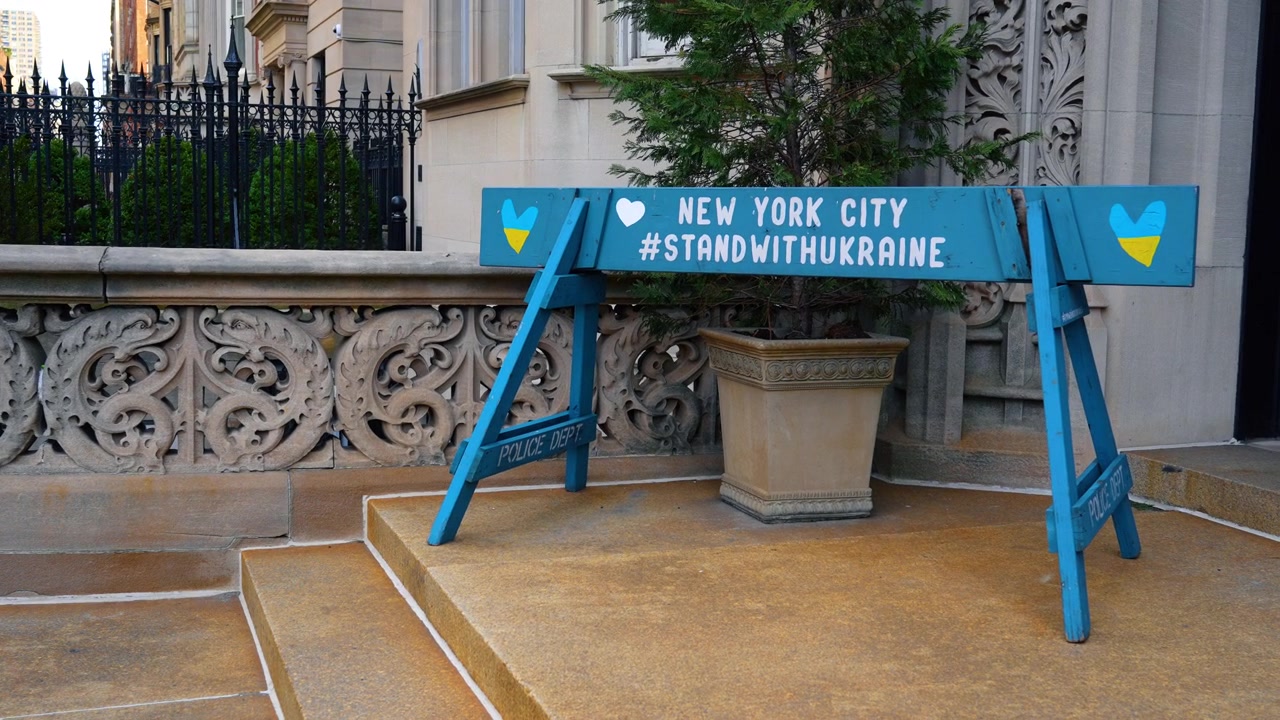 New York, USA, 3 aprile 2026: Segno di solidarietà dipinto di blu sui gradini di un edificio ornato, New York. Vista a livello della strada, facciata in pietra decorativa, fioriera, recinzione in ferro e luce del giorno laterale.