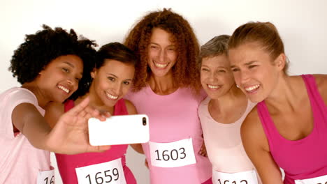 cinco atletas mujeres sonrientes tomando una selfie