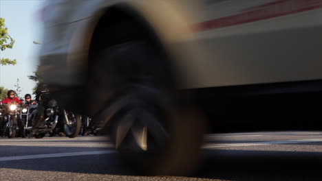 low angle shot of otorbikes starting at a crossing on a big street at sunset