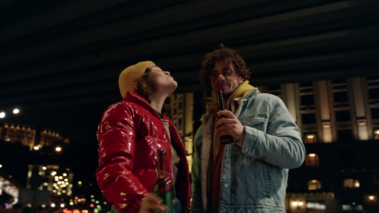 счастливая пара пьет пиво на улице.