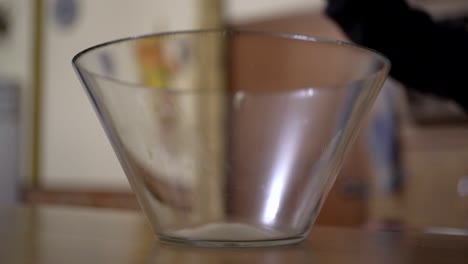 anonymous person pouring popcorn into a bowl