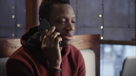 man talking on phone in a cafe