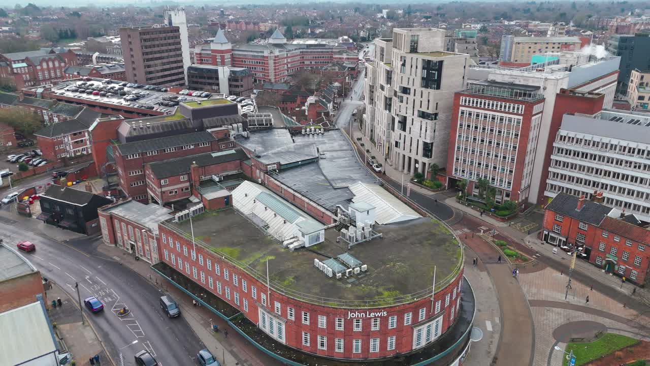 A bustling street in Norwich with buildings, shops, turrets, and John Lewis view