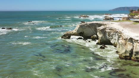 Rocky-white-cliffs-along-the-Southern-California-coast-near-Pismo-Beach-slow-motion-aerial-view