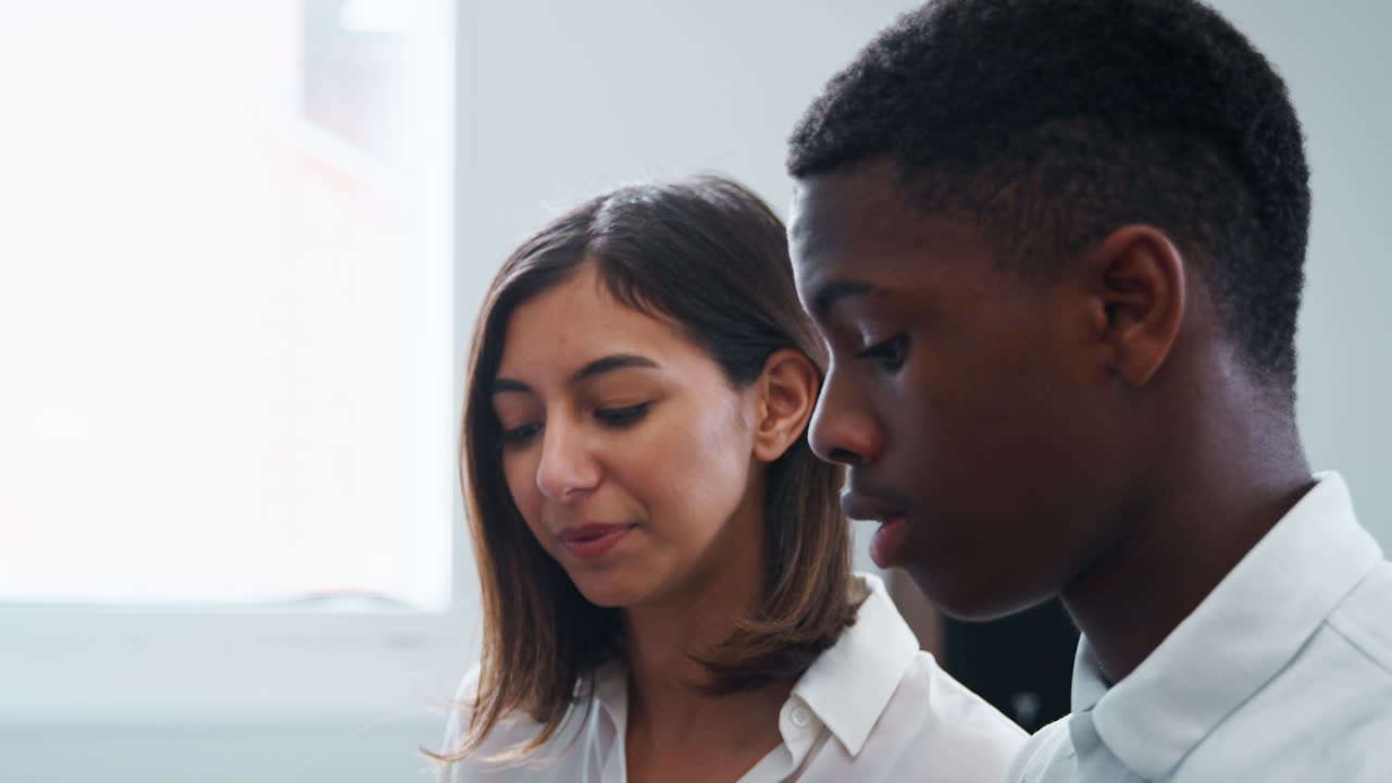 alumno con el profesor tocando el piano en la lección de música