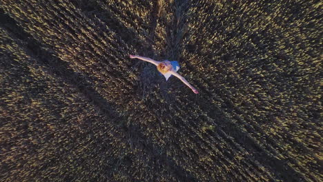 Young-woman-spining-in-summer-field.-Girl-in-wheat-field