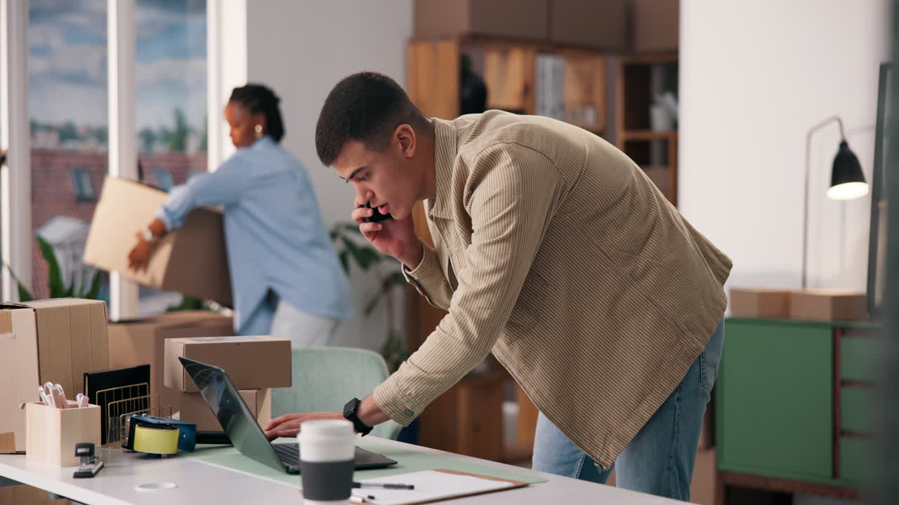 Man talking on the phone in an office with boxes