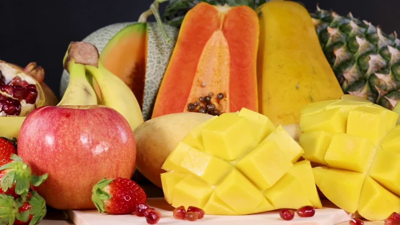 A colorful display of fresh papaya, mango, kiwi, and other tropical fruits arranged beautifully.