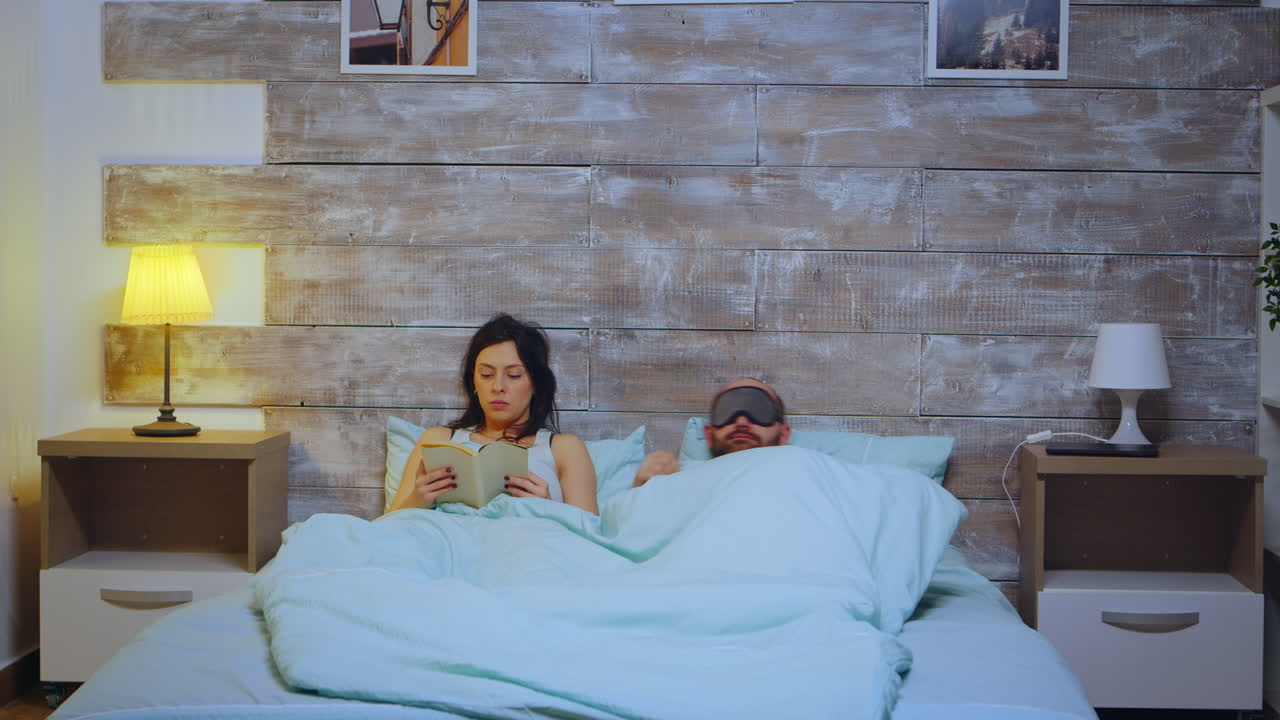 침실에서 잠옷을 입고 책을 읽는 여자