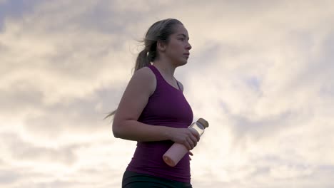 mujer de pie en la colina después del entrenamiento contraste amanecer cielo detrás