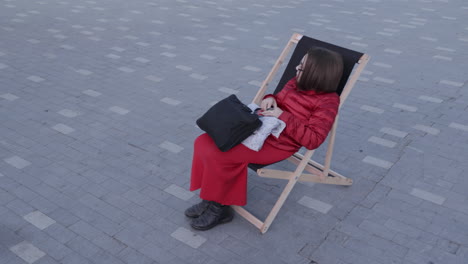 woman sitting in a wooden chair outdoors