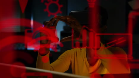 varios iconos digitales flotando contra una mujer de negocios afroamericana que usa auriculares vr en la oficina
