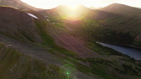 Beautiful-sunflare-across-stunning-guanella-pass-mountain-landscape-of-colorado-with-body-of-water-below