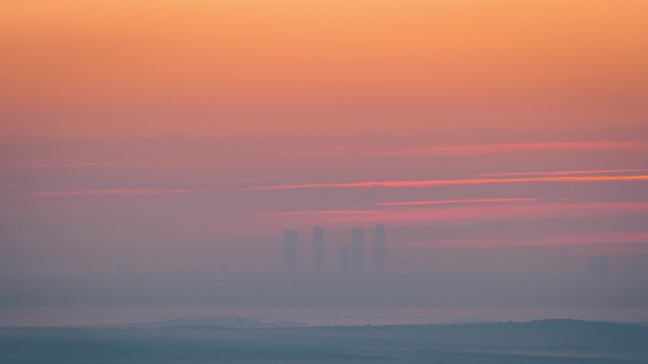 저속 마드리드 스카이라인 5는 겨울 안개와 낮은 구름 속에서 일출 동안 고층 빌딩을 탑니다