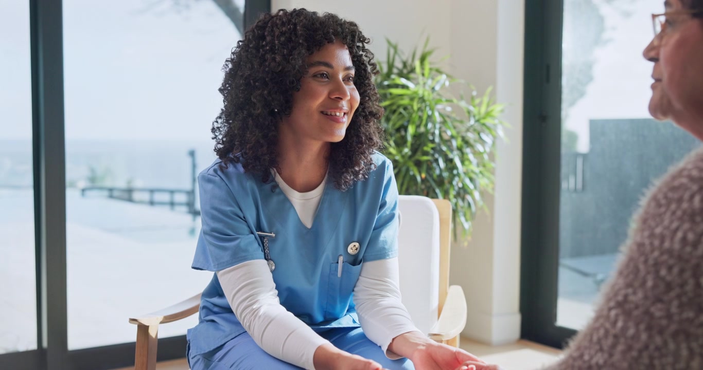 Friendly Nurse Talking to Senior Patient During Home Visit