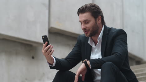 Business-man-waving-hand-at-phone-camera.-Executive-having-online-job-interview