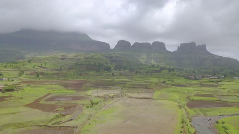 Campo-Exuberante-Y-Valles-Rocosos-En-Maharashtra,-Trimbakeshwar,-India,-Bajo-Las-Nubes-De-Tormenta-Durante-La-Temporada-De-Monzones---Toma-Panorámica