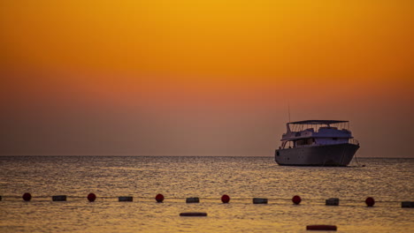 Anchored-on-Ocean-during-orange-colored-sky,-time-lapse-shot