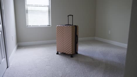 slow mo of entering a sunny empty room with just a bad of luggage