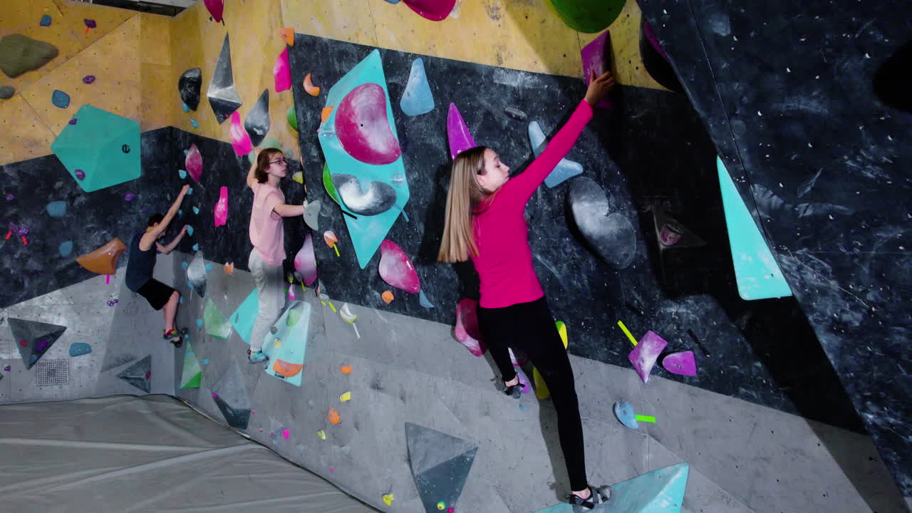 adolescentes haciendo bouldering en un gimnasio