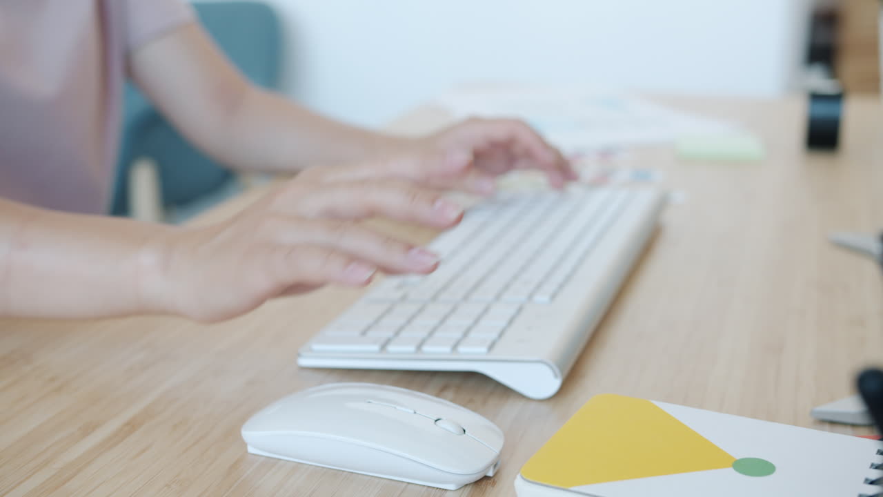 Woman working at a desk with keyboard and mouse