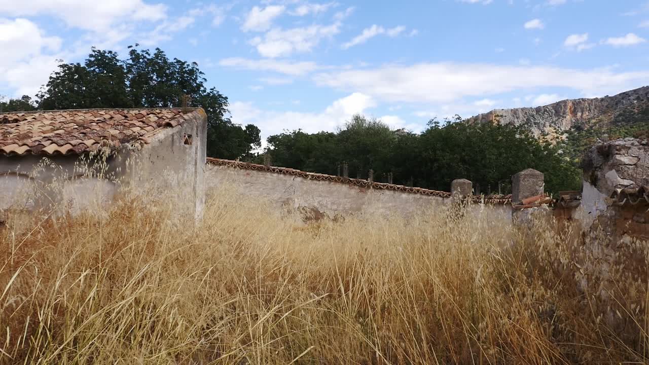 Panoramic view of the abandoned cemetery in the village of Otiñar, Jaén. It shows ruined tombs and stone walls