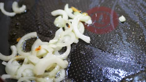 onion fried in a pan close-up. steam in a pan while frying vegetables