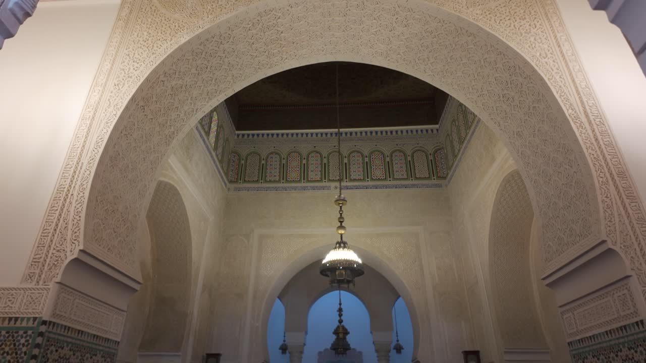 Traditional Moroccan architecture and design are displayed within the serene Mausoleum of Moulay Ismail, located in Meknes, Morocco. Tilt Down Shot