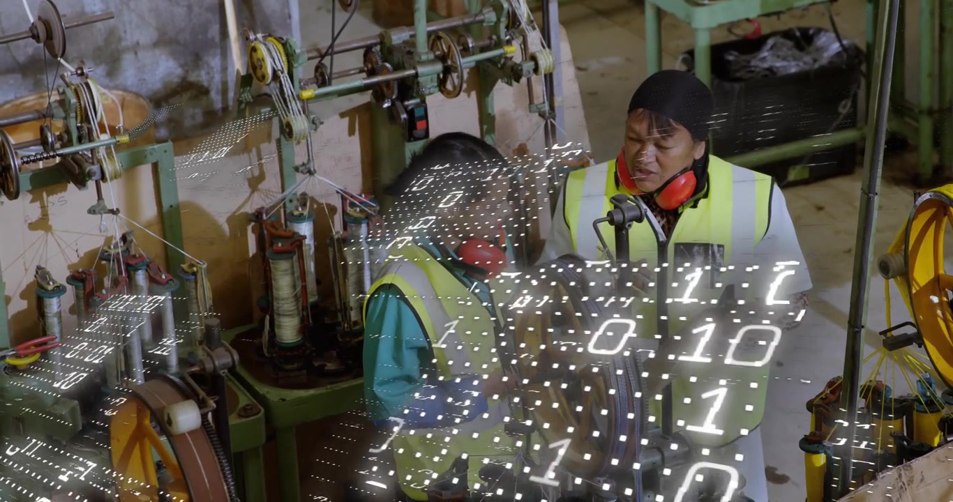 Factory Workers Inspecting Industrial Machinery with Digital Data Overlay