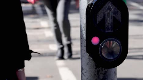 person pressing button at pedestrian crossing in melbourne