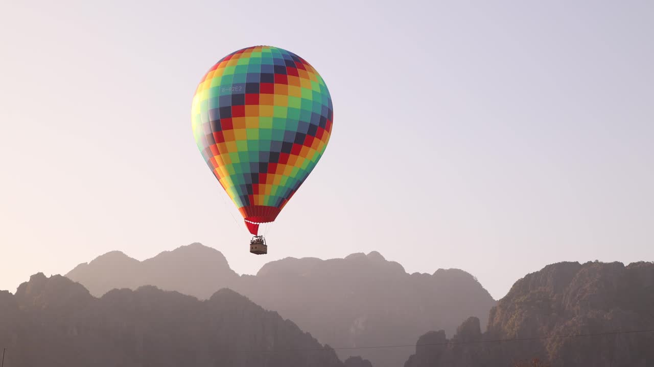 colorful hot air ballon floating over mountains in Vang Vieng, the adventure capital of Laos