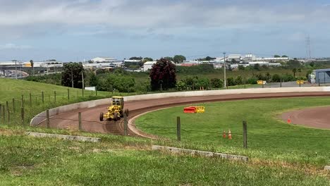 tractor working on a racing runway on a sunny day