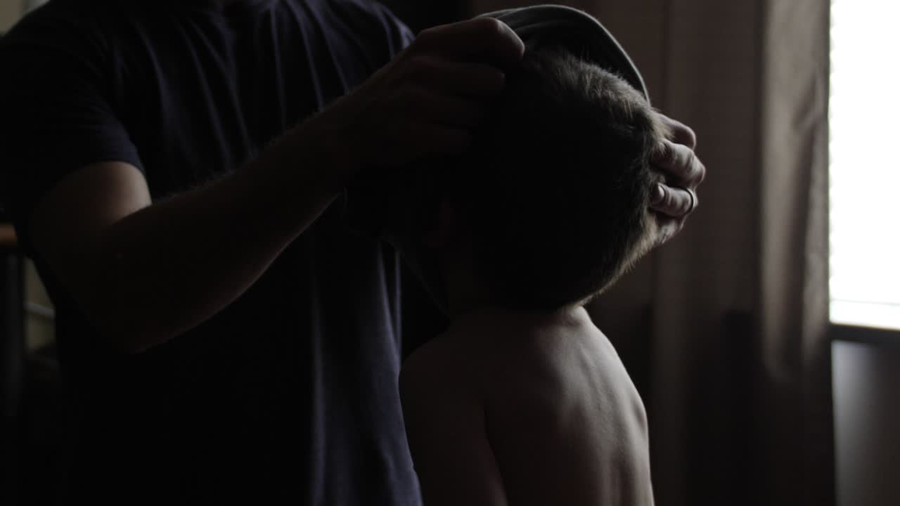 그의 아버지에 의해 옷을 입고 어린 소년