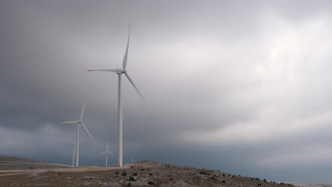 a large wind turbine plant. sustainable and renewable green energy from the wind. turbines arranged on a mountain plateau. windy weather before the storm.