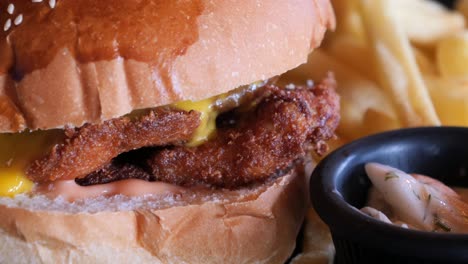 close up of a crispy chicken sandwich with fries and coleslaw