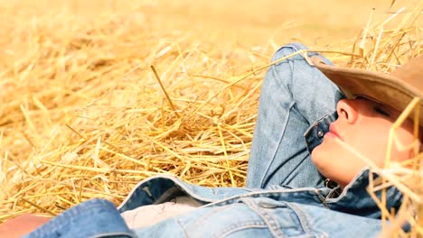 mujer pacífica con sombrero de vaquero acostada en heno