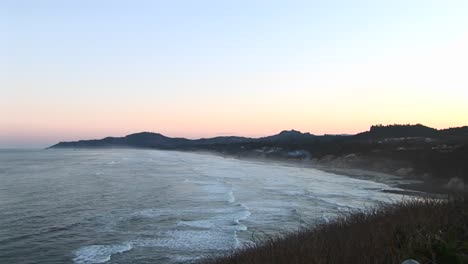 The-Tide-Rolls-Into-A-Small-Inlet-With-Rocks-Sand-And-Seagrasses-Lining-Its-Shore