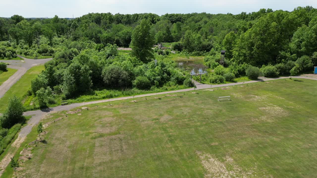 parque de campamento de verano con campo de redes de fútbol cerca de bosque caducifolio, aéreo