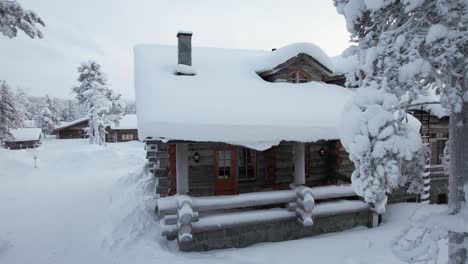 el avión no tripulado vuela hacia y por encima del techo cubierto de nieve de la cabina en laplandia, finlandia, círculo ártico