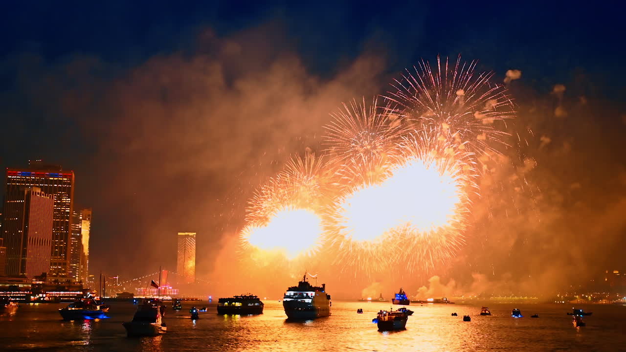 Fascinating firework show over the river waterscape. Multiple diverse boats are on the waterscape colored by the flashes. New York city celebration