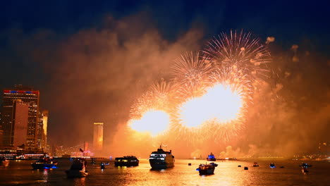 fascinating firework show over the river waterscape. multiple diverse boats are on the waterscape colored by the flashes. new york city celebration