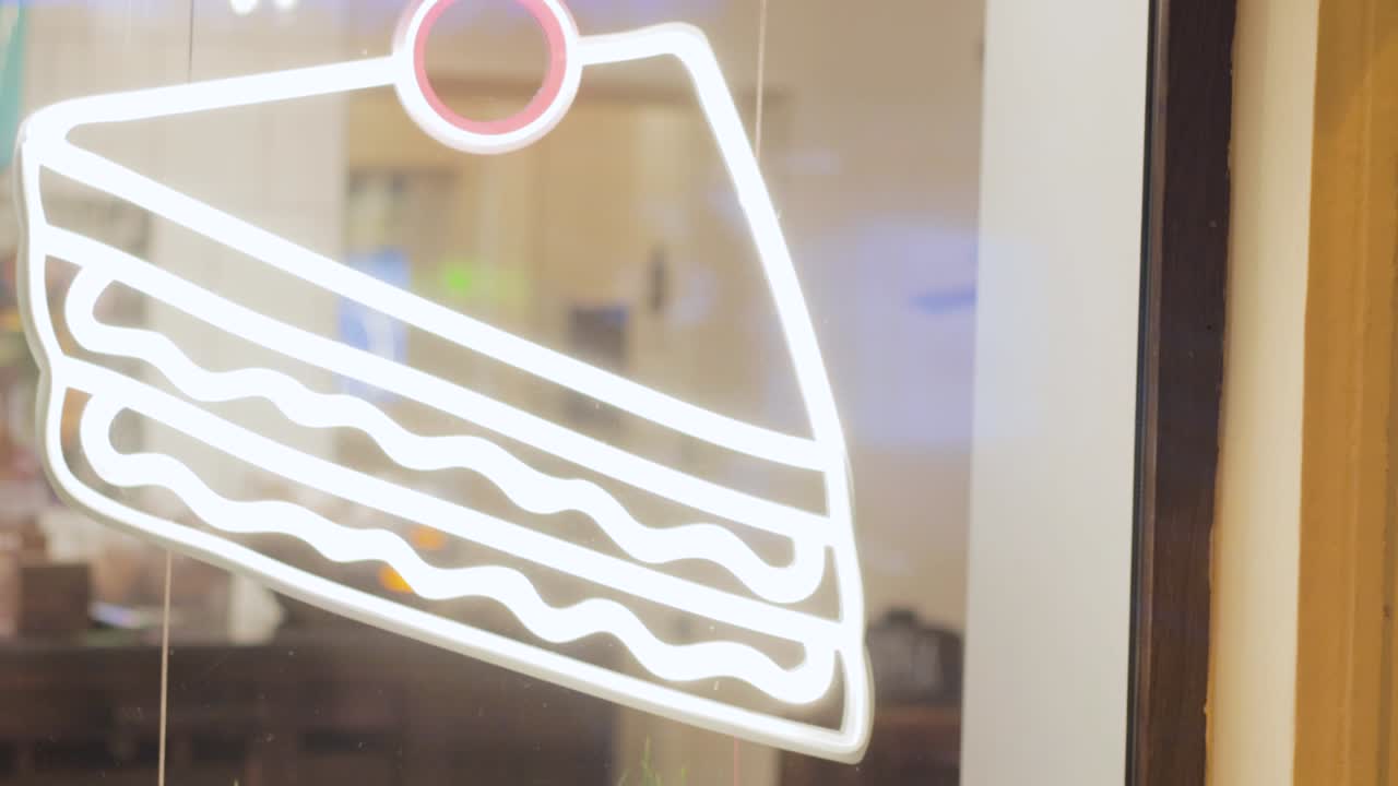 neon sign tasty cake on the shop window at night glows