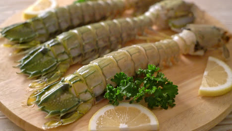 fresh mantis shrimp with lemon on wood board